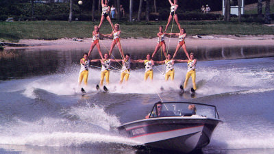 Water skiers pyramid being pulled by Ski Nautique boat